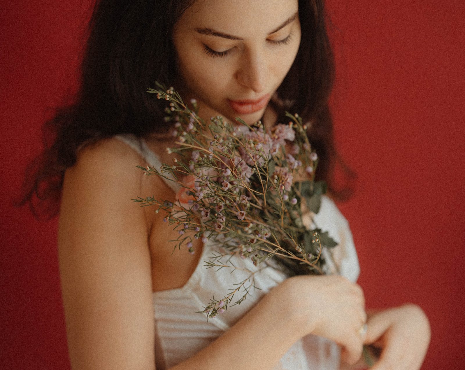 Photographie douce d'une femme avec un bouquet de fleur dans les bras