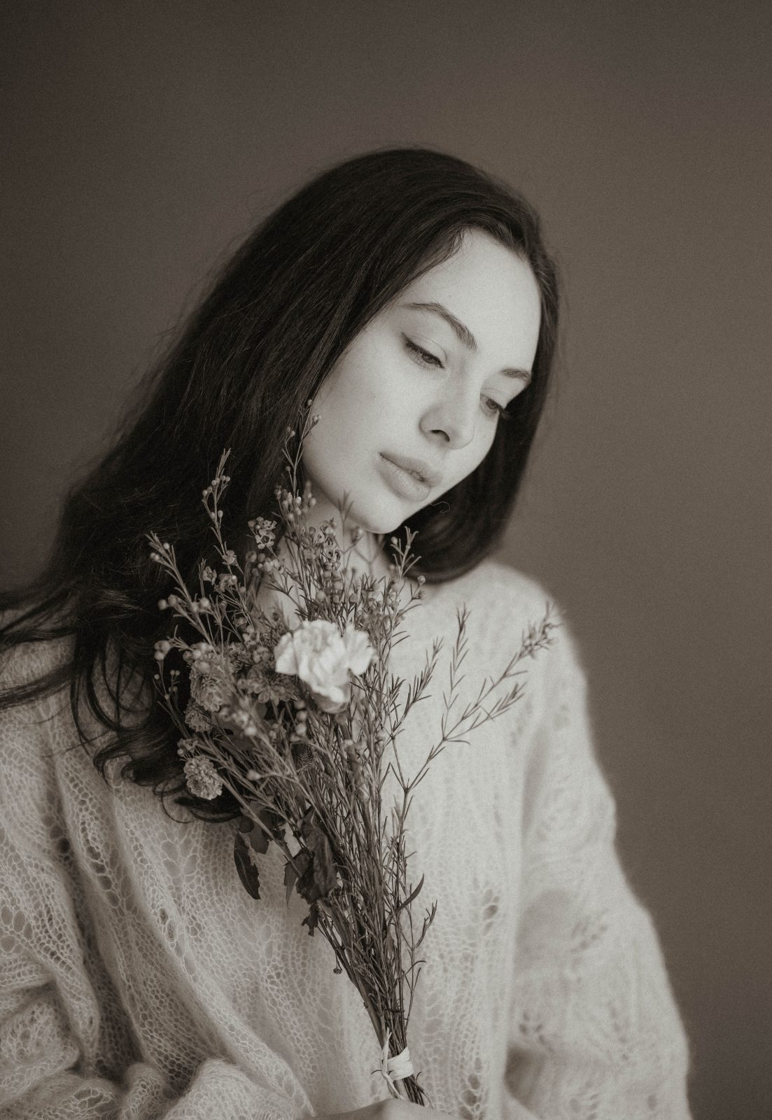Portrait d'une femme en noir et blanc avec un bouquet de fleurs