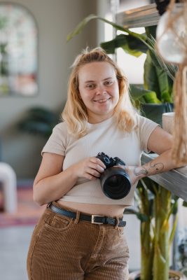 Portrait d'une photographe regardant l'objectif et en tenant son appareil photo dans les mains