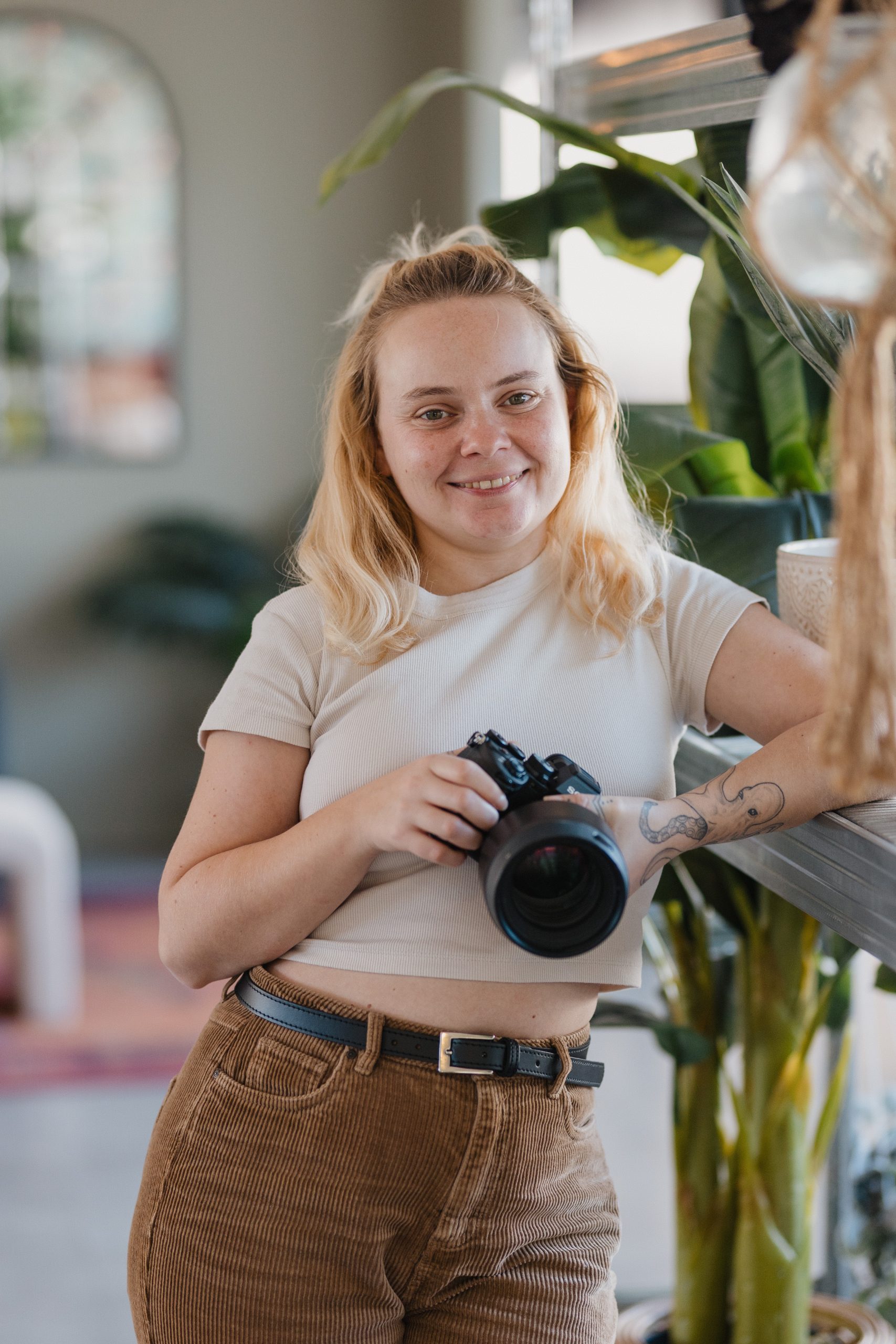 Portrait d'une photographe regardant l'objectif et en tenant son appareil photo dans les mains