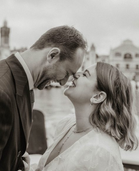 Photo d'un couple de jeunes mariés face à face qui rigolent, en noir et blanc